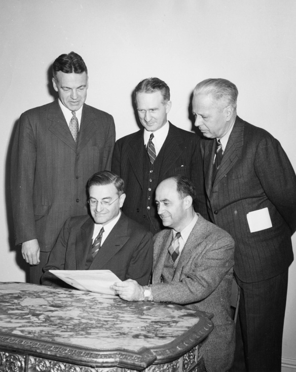 Photograph by Lionel Heymann of Robert Maynard Hutchins, University of Chicago president (1929-1945) and chancellor (1945-1951), with team members of the Manhattan Project, the program established by the United States government to build the atomic bomb. Standing, from left: Mr. Hutchins, Walter H. Zinn, and Sumner Pike; seated: Farrington Daniels, and Enrico Fermi. University of Chicago Photographic Archive, [apf digital item number, e.g., apf12345], Special Collections Research Center, University of Chicago Library. accessed at http://photoarchive.lib.uchicago.edu/db.xqy?one=apf1-05063.xml